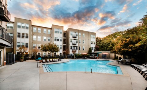 a swimming pool with an apartment building in the background